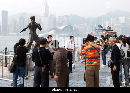 Touristen werden vor einer Statue von Bruce Lee auf der Avenue of Stars in Hongkong gesehen. Stockfoto