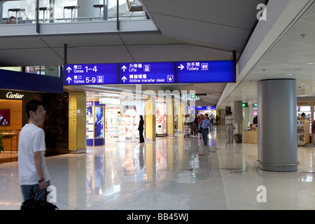 Reisende sind in der Abflughalle des Hong Kong International Airport gesehen. Stockfoto