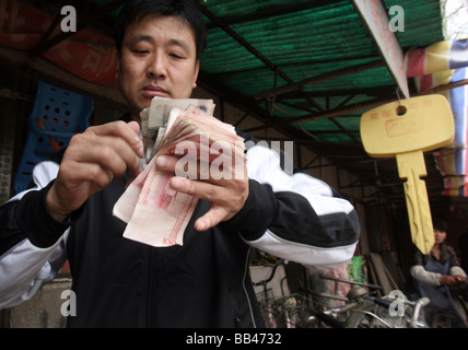 Man zählt chinesisches Geld in Songzhuang, Beijing, China. Stockfoto