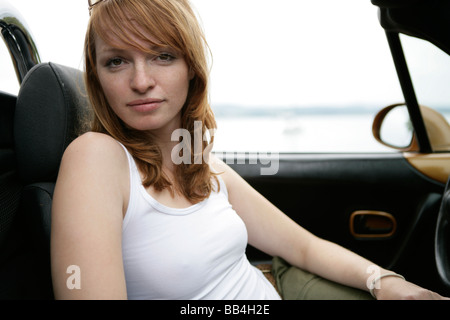 Porträt der jungen Frau im Auto am See Stockfoto