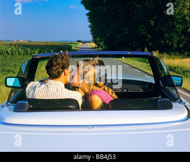 FRAU KÜSST MANN AUF DIE WANGE, WÄHREND SIE CABRIOLET-STRASSE ELSASS FRANKREICH EUROPA FÄHRT Stockfoto