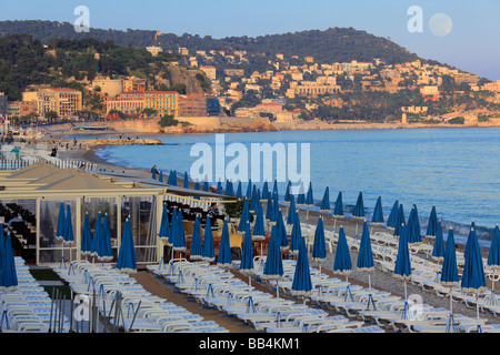 Strand entlang der Promenade Des Anglais in Nizza an der französischen Riviera, Straße, wie der Vollmond steigt und die untergehende Sonne. Stockfoto