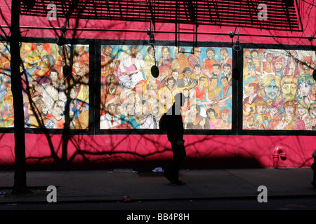 Ein Mann geht vorbei ein Wandbild von berühmten Musikern auf West 3rd Street, im Dorf in New York City Stockfoto