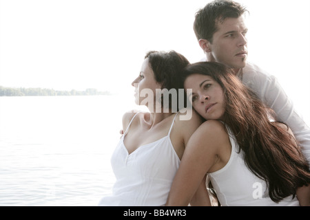 Mann und zwei Frauen sind entspannend am Meer Stockfoto