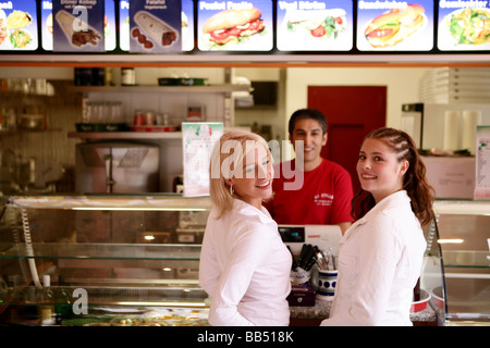 zwei Teenager weiblich lachen an der Theke im Take-away-restaurant Stockfoto