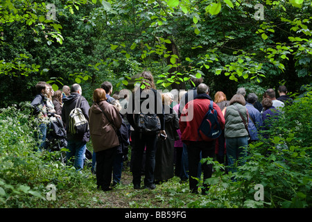 Besuchern stehen im Wald eine Anleitung geben einen Vortrag anhören, während einer Tour durch Nunhead Friedhof am jährlichen Open-Tag Stockfoto