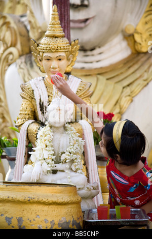 Burmesische Mädchen gießt Wasser über Buddha-Statue. Planetare Post für Jupiter (Donnerstag). Shwedagon-Pagode. Yangon. Myanmar Stockfoto