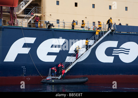 Passagiere in kaltem Wetter gang Boarding russischen Eisbrecher Kreuzfahrtschiff von Zodiac Boot nach Ausflug in die Antarktis über hohen Gangway Treppen Stockfoto