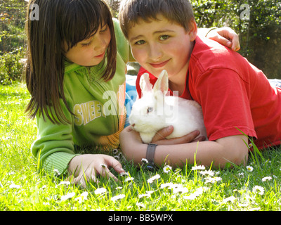 Zwei Kinder mit einem Kaninchen junge Mädchen Stockfoto
