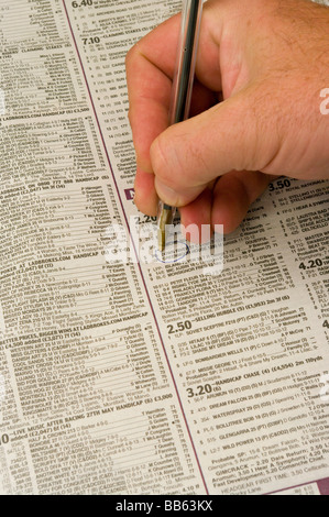 Mans Hand mit einem Stift, eine Pferd-Auswahl In einer Zeitung Stockfoto