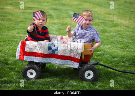 Zwei junge Burschen sitzen in Wagen mit amerikanischen Flaggen Stockfoto