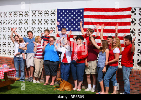 Große Gruppe von Menschen vor amerikanischen Flagge winken Hände Stockfoto