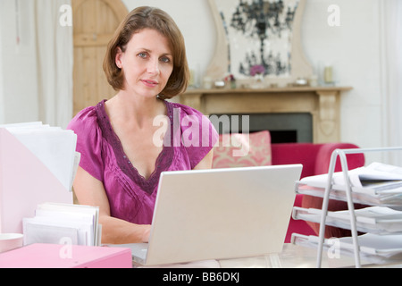 Frau sitzt am Schreibtisch und Laptop verwenden Stockfoto