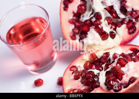 Pmegranate halbieren auf weißem Hintergrund und ein Glas Saft Stockfoto