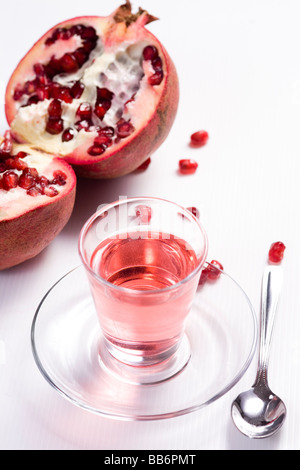 Pmegranate halbieren auf weißem Hintergrund mit Grenadine Saft Stockfoto