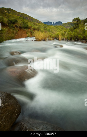 Die Del "hlwazini Fluss in der Injisuthi Teil der Drakensberge mit Mönch Gugel und Cathkin Peak durch den Sonnenaufgang beleuchtet wird. Stockfoto