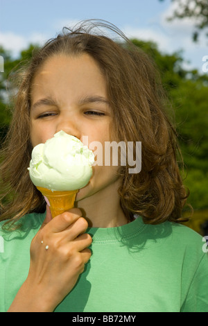 Junge genießt eine Eiscreme-Kegel im Park. Stockfoto