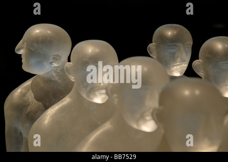Linien von Glasfiguren mit einem individuellen Kopf schauen in eine andere Richtung Stockfoto