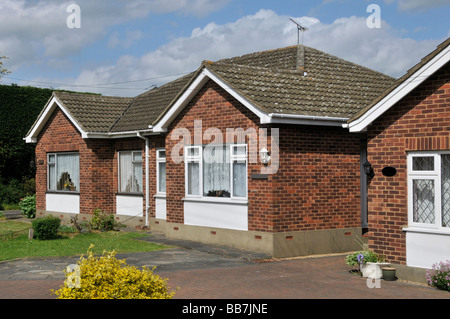 Doppelhaushälften aus Ziegelstein, passende Paarbungalowhäuser, Betondachdachvordächer in ländlicher Dorflage in der Nähe von Brentwood Essex England Großbritannien Stockfoto