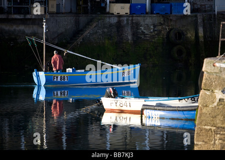 Fischer setzt die Segel in den Morgenstunden von Mevagissey Hafen, Cornwall, UK Stockfoto