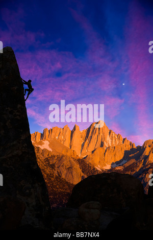 Ein Bergsteiger ist gegen den Abendhimmel abhebt, wie er klammert sich an einer steilen Felswand in den Sierra Nevada Mountains Kalifornien Stockfoto