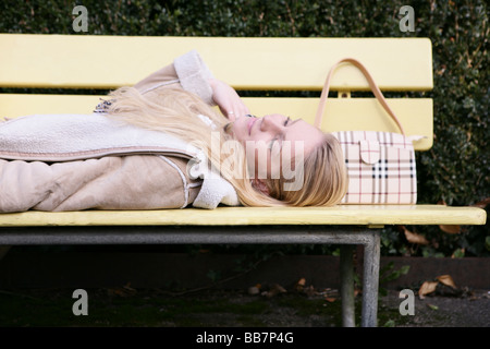 Porträt einer Frau ist auf einer Bank in einem Park liegen. Stockfoto