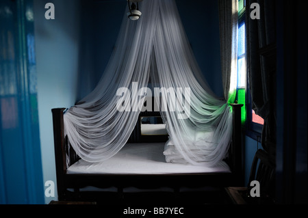 Weißes Moskitonetz über dem Bett in einem Hotel. Stockfoto
