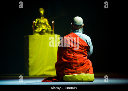 Shaolin-Mönch betend vor einer Buddhastatue Stockfoto
