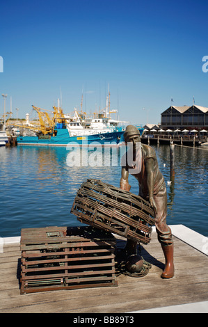 Statue eines Fischers mit einem Hummer Topf auf dem Kai an der Fishing Boat Harbour, Fremantle, Western Australia Stockfoto