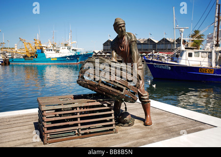 Statue eines Fischers mit einem Hummer Topf auf dem Kai an der Fishing Boat Harbour, Fremantle, Western Australia Stockfoto