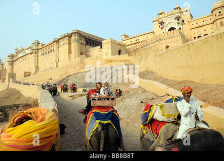 Touristen auf Elefanten steigen wieder auf eines der wichtigsten Tore Suraj Pol des Amber Fort. Stockfoto