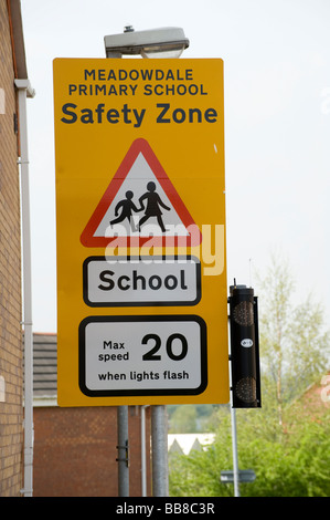 Gelbes Schild zeigt eine Geschwindigkeitsbegrenzung von 20 Meilen pro Stunde Schule zeitweise in eine Sicherheitszone außerhalb einer Schule Stockfoto