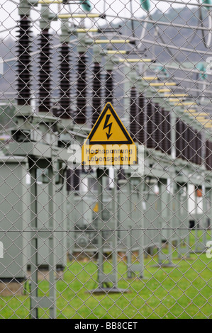 Zeichen, Hochspannung, Lebensgefahr auf einem Maschendrahtzaun vor ein elektrisches Umspannwerk Stockfoto