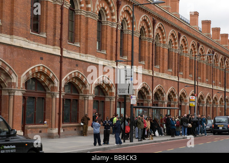 Menschen, die Schlange für einen Bus außerhalb St. Pancras Station, Kings Cross, London UK Stockfoto