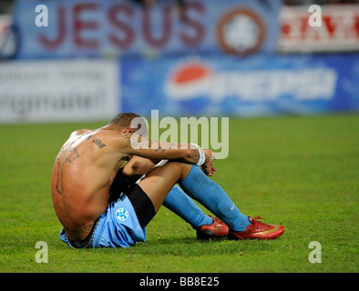 Orlando Smeekes, Stuttgarter Kickers, mit religiösen Tatoos, enttäuscht, sitzen auf dem Boden nach dem Verlust, Jesus geschrieben am Stockfoto