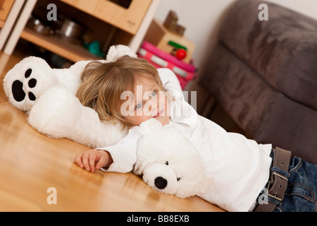 Kleiner Junge, 3 Jahre alt, auf ein Spielzeug Eisbär liegend entspannt Stockfoto