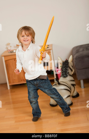 Kleiner Junge, 3 Jahre alt, posiert mit einem Schwert Stockfoto