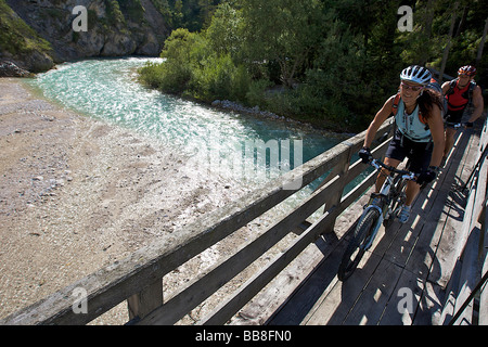 Montainbike Reiter, weiblich und männlich, auf einer hölzernen Brücke, überqueren die Isar in der Nähe der Wiesenhof Hotel, in der Nähe von Scharnitz, Tyro Stockfoto