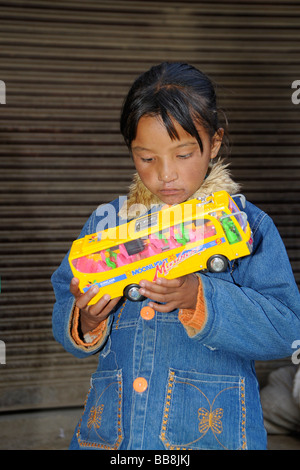 Ladakhi Kind blickte staunen über ein billiges Spielzeug aus Plastik, Leh, Ladakh, Nord-Indien, Himalaya, Asien Stockfoto