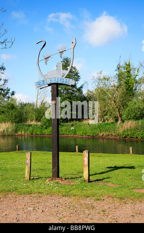 Ortsschild an Belaugh, Norfolk, Großbritannien, mit dem Fluss Bure im Hintergrund. Stockfoto