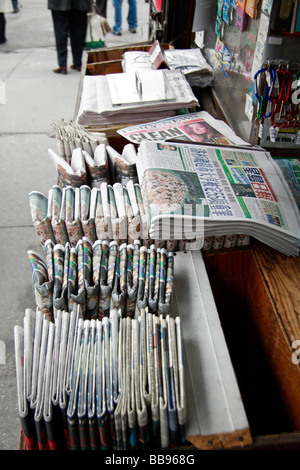 Eine Reihe von englischen und fremdsprachige Zeitungen auf dem Display an einem Zeitungskiosk in Chinatown, New York. Stockfoto