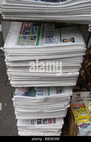 Ein Rack mit fremdsprachigen Zeitungen auf dem Display an einem Zeitungskiosk in Chinatown, New York. Stockfoto