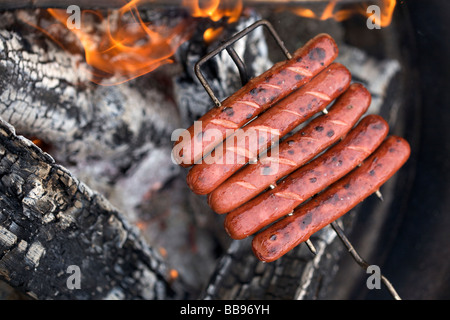 Hot Dogs auf ein Lagerfeuer rösten Stockfoto