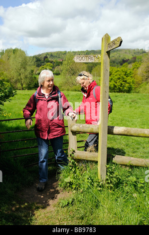 Weibliche Wanderer Wandern durch ein Feld durch eine ab-Hof Stockfoto