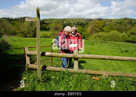 Weibliche Wanderer Wandern durch Stillstand Feld auf eine Karte anzeigen Stockfoto