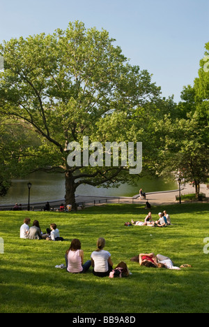 Menschen entspannen auf der Liegewiese am Konservatorium Wasser Teich im Central Park New York City Stockfoto