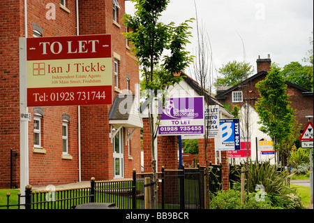 Für Verkauf und "Lassen Sie" Zeichen aus verschiedenen lokalen Maklern außerhalb einer neu erbauten Wohnblock in Frodsham Cheshire Stockfoto