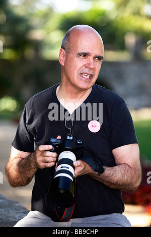 Professioneller Fotograf eine Pause zwischen den Aufnahmen. Er nutzt eine Dslr-Kamera mit einem Teleobjektiv. Stockfoto