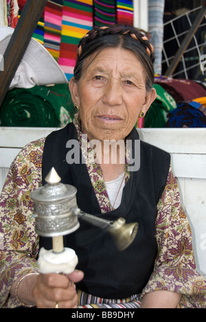 Vertikale Porträt einer alten tibetischen Frau Spinnen ihre Gebetsmühle auf der Barkhor, Lhasa, Volksrepublik China Stockfoto