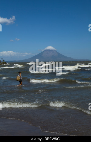 Eine nicaraguanische Frau trägt einen Eimer Wasser vom See Cocibolca gegenüber la Isla de Ometepe San Jorge Nicaragua füllen Stockfoto